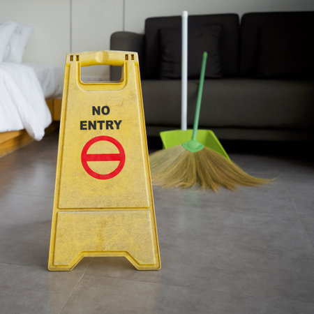 A yellow "NO ENTRY" sign place on the floor in hotel room. While cleaningの写真素材