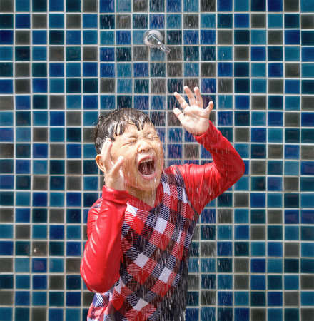 Asian kid wash salt water out of his face after playing in the swimming pool.の写真素材