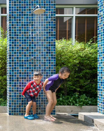 Asian kid wash salt water out of their butt and body after playing in the swimming pool.