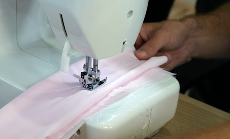 The dressmaker elaborately made  thread pattern on a fine pink fabric.の写真素材