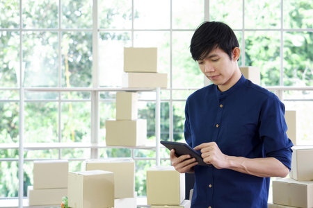 Young entrepreneur checking products stock with tablet computer at home office. Work from home...