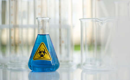 Erlenmeyer Flask contains blue liquid chemicals on white laboratory table.の写真素材
