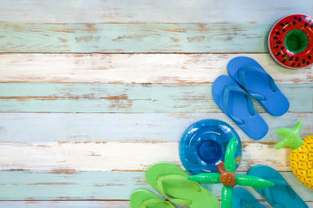Sponge shoes and inflatable toys for traveling on wooden floor, prepare for a holiday trip. Summer travel concept. (Studio Shot)の写真素材