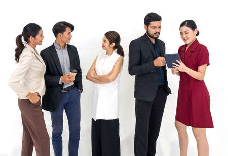 Team of successful young people standing together. Some people drink coffee some people using tablet computer. Portrait on white background with studio light.の写真素材