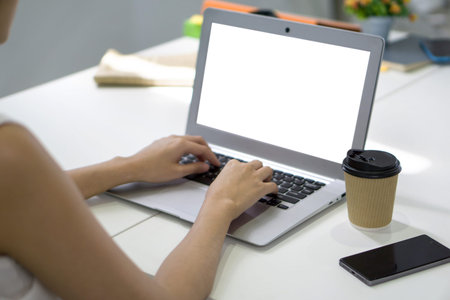 Back view of businesswoman sit at desk in office typing on laptop computer keyboard with white...