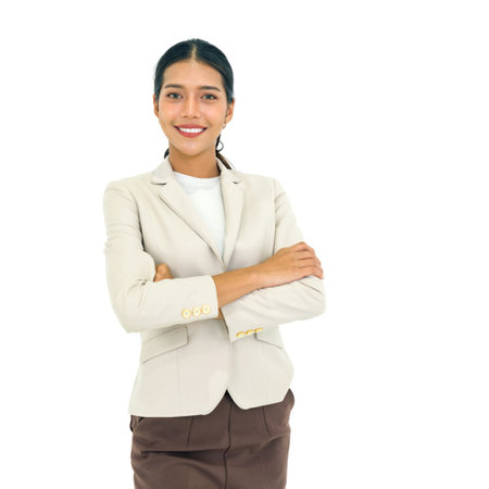Young asian businesswoman with a smile in brown suit stand with folded arms in front of white wall. Portrait on white background with studio light.の写真素材