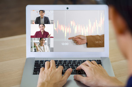 Back view of businessman typing on laptop computer keyboard while videoconference on-line meeting...