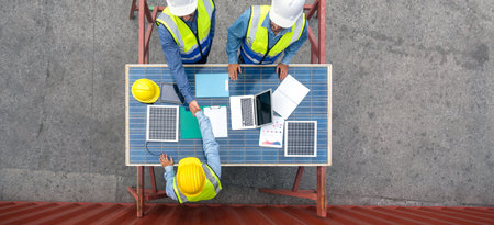Young engineer in hardhat and safety vest shake hands with project manager after agreeing a business...