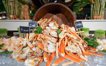 Superbly cooked fresh seafood cold station at International Buffet Restaurant. Prawn, Crab and Scallop on ice decorated with wooden bucketの写真素材