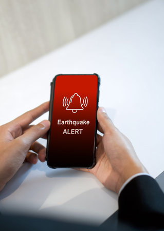Earthquake alert warning displayed on smartphone screen as symbol, telling people to be careful....