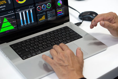 Data analysis and visualization in a professional environment using a laptop with multiple chart and graphの写真素材