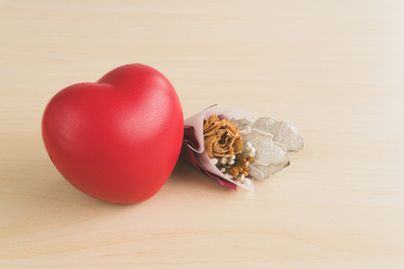 Red love heart and dried flower bouquet on wood tableの写真素材