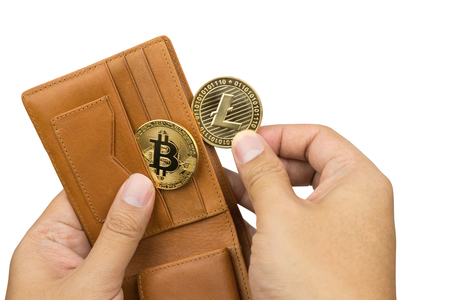 crypto currency concept, hand taking out litecoin and bitcoin from brown leather wallet, isolated on white backgroundの写真素材