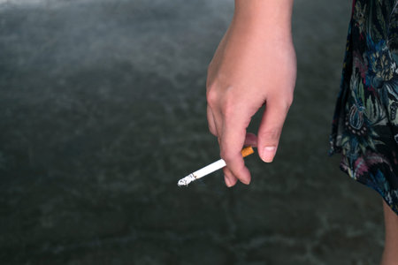 woman hand holding a burning cigarette