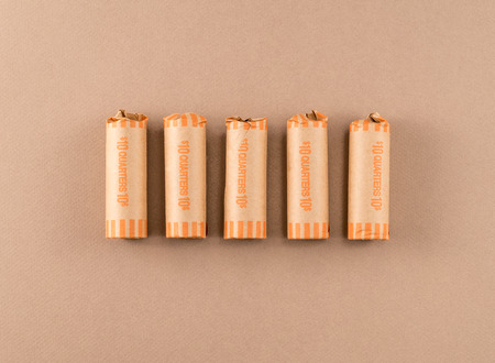 Quarters in Coin Wrappers on Tan Backgroundの写真素材