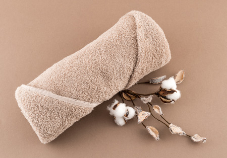 Spa Luxury Towel and Cotton Branch on Tan Backgroundの写真素材