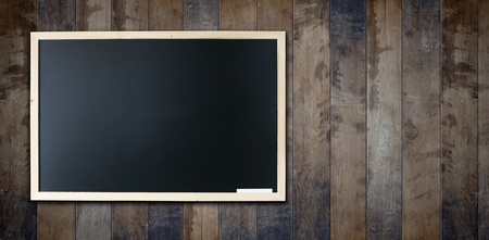 Blank chalkboard in wooden frame on wooden wall の写真素材