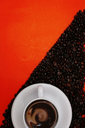 white coffee cup and beans on red backgroundの写真素材