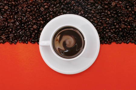 white coffee cup and beans on red backgroundの写真素材