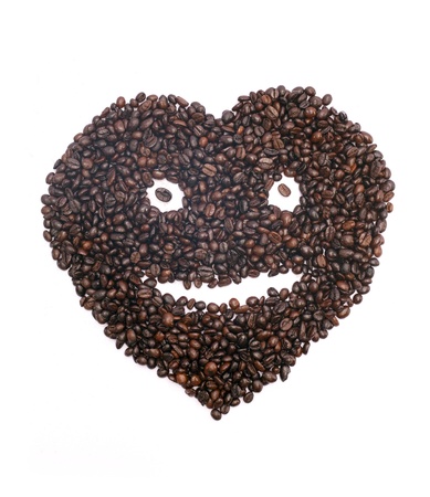 Coffee beans in the form of heart smiles on white background の写真素材