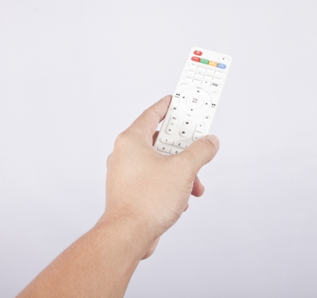 Hand with TV remote control on white の写真素材