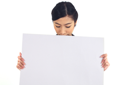 Happy smiling young business woman showing blank signboard, over white backgroundの写真素材