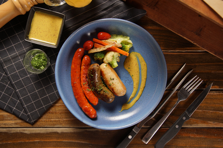 grilled sausages on wooden table, top viewの写真素材