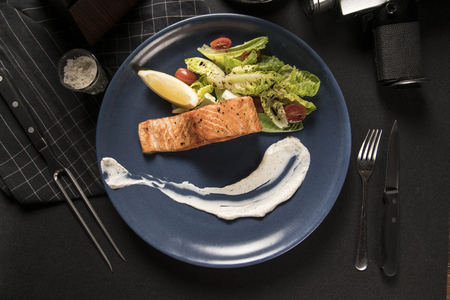 Grilled salmon with lemon, asparagus on dark background.の写真素材