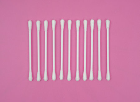 ear sticks cotton on pink background.