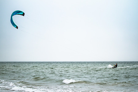 kitesurfer cutting waves from a distanceの写真素材