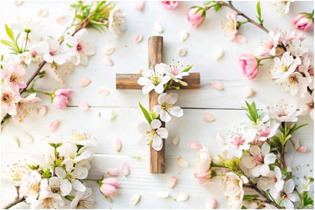 Wooden cross surrounded by spring flowers on white woodの素材