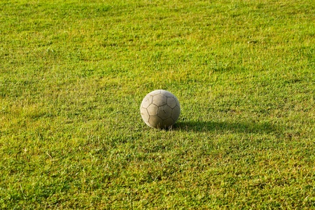 Old soccer ball on the green grass. の写真素材