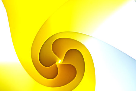 background macro image of a pattern made of curved sheets of paper in yellow .