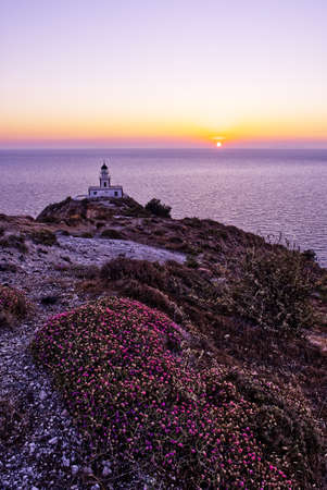 Akrotiri Lighthouse on the Santorini coast during sunsetの写真素材