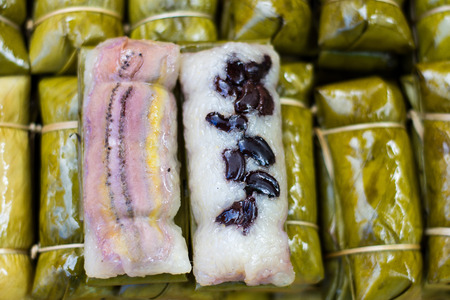 Selective focus in center, Bananas with sweet sticky Rice wrap in banana leaves at Thai rural market, Thai dessertの写真素材