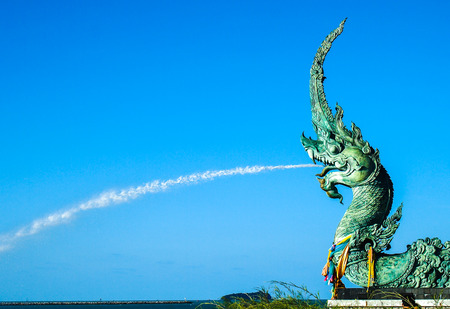 Naga statue spray  water to the sea with blue sky backgroundの写真素材