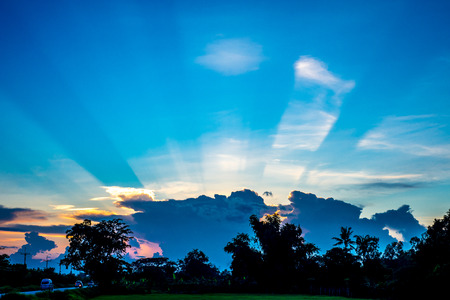 sunburst behind the clouds with blue sky background.の写真素材