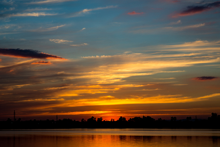 amazing golden sunset sky  with reflection on calm lakeの写真素材