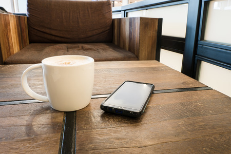 A cup of coffee latte and smart phoneの写真素材