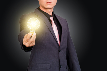 Businessman showing creative business strategy with light bulb as conceptの写真素材