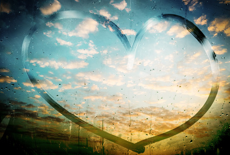 Heart on foggy window and rain dropsの写真素材