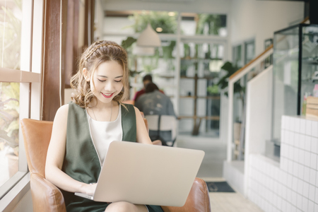 Confident happiness young woman working on laptop or notebook in her office. Beautiful Freelancer Woman working online at her home. Beauty Asian business woman concept.の写真素材