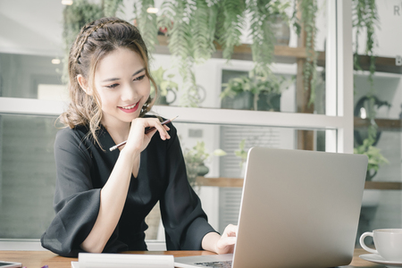 Confident happiness young woman working on laptop or notebook in her office. Beautiful Freelancer Woman working online at her home. Beauty Asian business woman concept.の写真素材