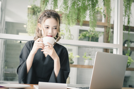 Confident happiness young woman working on laptop or notebook in her office. Beautiful Freelancer Woman working online at her home. Beauty Asian business woman concept.の写真素材