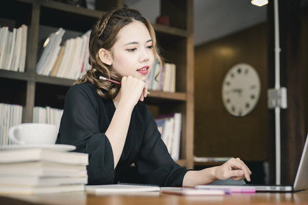 Confident happiness young woman working on laptop or notebook in her office. Beautiful Freelancer Woman working online at her home. Beauty Asian business woman concept.の写真素材