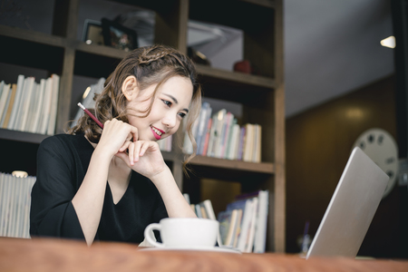 Confident happiness young woman working on laptop or notebook in her office. Beautiful Freelancer Woman working online at her home. Beauty Asian business woman concept.の写真素材