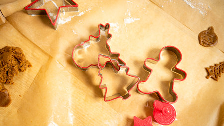 Red ginger bread shapes and dough laying on brown baking paper. Baking gingerbread.