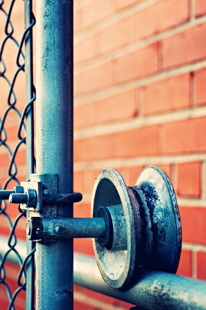 Metal fence against brick wallの写真素材