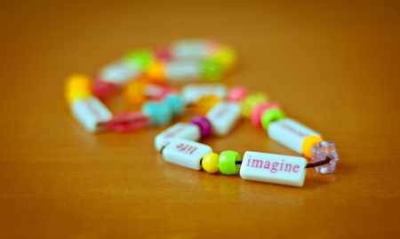 Colorful beaded necklace with word imagineの写真素材