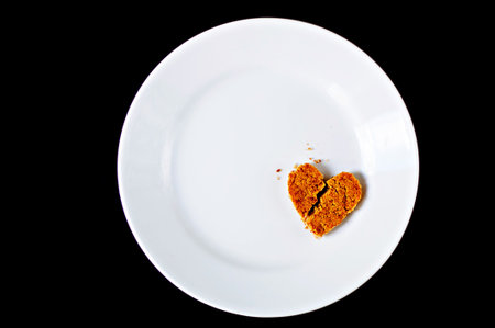 Broken heart cookie on white plateの写真素材